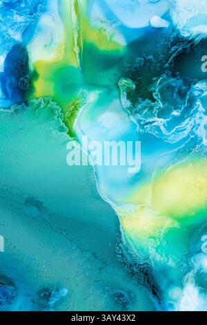 Mesmerizing flow of liquid abstract inks in vibrant blue, green, and yellow colors, creating an organic and ethereal aesthetic ideal for artistic back Stock Photo