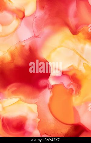 A vivid display of flowing abstract liquid inks, blending shades of yellow, red, and orange to create a warm, dynamic background. Stock Photo