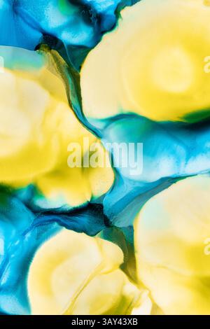Vivid abstract art featuring flowing inks in shades of blue, teal, and yellow, creating a mesmerizing liquid blend. Stock Photo