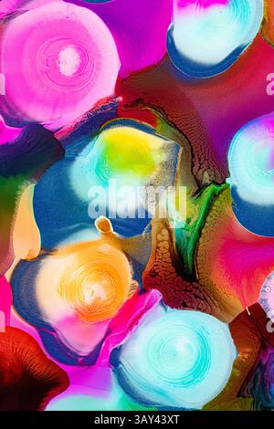 A mesmerizing array of vibrant ink swirls in bright shades of pink, blue, yellow, green, and brown, set against multicolored backgrounds. The dynamic Stock Photo