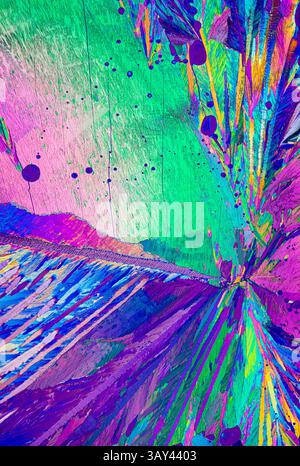 Vivid and colorful polarized light microscopy image of Adipic acid, crystals showcasing vibrant hues of pink, green, blue, and purple with dynamic tex Stock Photo