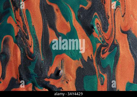 A vibrant abstract background featuring swirling patterns of orange and green metallic paints with a textured surface. Stock Photo