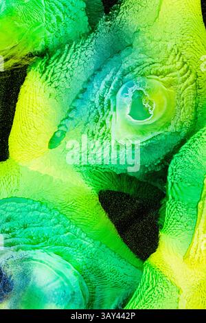 A vibrant abstract image featuring swirling greens and yellows with galaxy, liquids patterns. The textured surface offers a sense of depth and dynamic Stock Photo