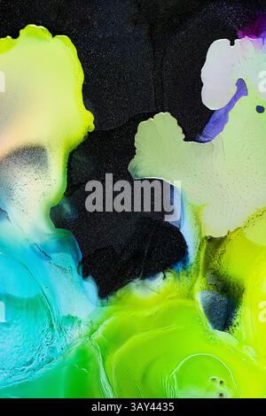 Vivid abstract artwork with bright splashes of green, blue, and purple on a dark background. The vibrant colors and liquids shapes create a dynamic, g Stock Photo