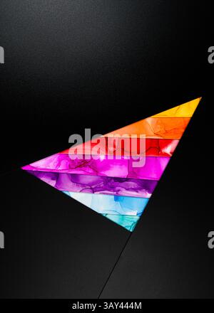 A bold triangular design featuring vibrant colors inks like orange, red, purple, and blue against a dark background. The composition is modern and dyn Stock Photo