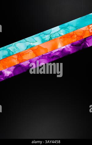 Vibrant diagonal colors inks stripes of teal, orange, and purple on a dark background. This abstract design is ideal for modern art and creative proje Stock Photo