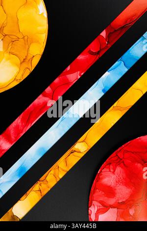 A vibrant abstract image featuring colorful geometric shapes on paper. Bold red, yellow, and blue inks create a dynamic pattern against a black backgr Stock Photo