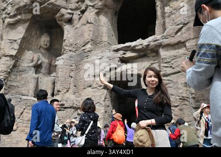 (250422) -- DATONG, April 22, 2025 (Xinhua) -- Tourists visit Yungang Grottoes in Datong, north China's Shanxi Province, April 16, 2025. Yungang Grottoes was built during the Northern Wei Dynasty (386-534). It is considered a pinnacle of Chinese Buddhist art and represents the highest level of sculptural artistry in the world during the 5th century.  In recent years, Shanxi has made great efforts to protect and study the grottoes. In 2021, the research institute of the Yungang Grottoes was established for the protection, research and management of the Yungang Grottoes.    Since 2003, the UNESC Stock Photo
