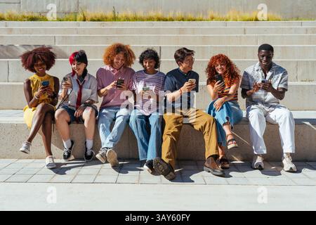 Multiethnic group of young friends meeting and having fun outdoors - Multiracial happy and stylish teen students bonding in the city, concepts about y Stock Photo