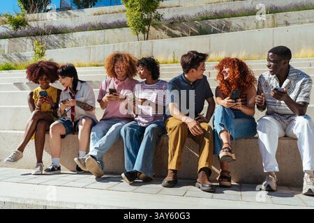 Multiethnic group of young friends meeting and having fun outdoors - Multiracial happy and stylish teen students bonding in the city, concepts about y Stock Photo
