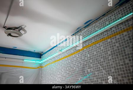 Laser-Guided Ceiling Installation in Progress in Bathroom. Stock Photo
