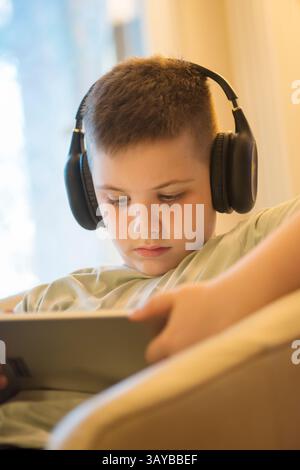 Boy in Headphones Using Digital Tablet Stock Photo