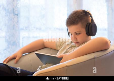 Boy in Headphones Using Digital Tablet Stock Photo
