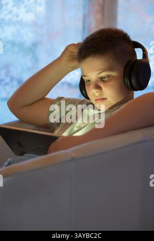 Boy in Headphones Using Digital Tablet Stock Photo