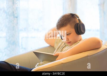Boy in Headphones Using Digital Tablet Stock Photo
