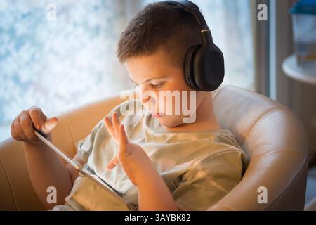 Boy in Headphones Using Digital Tablet Stock Photo