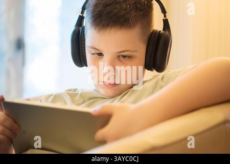 Boy in Headphones Using Digital Tablet Stock Photo