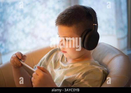 Boy in Headphones Using Digital Tablet Stock Photo