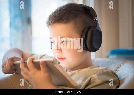 Boy in Headphones Using Digital Tablet Stock Photo