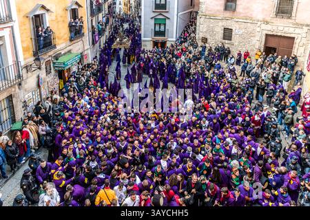 Turbas de Cuenca in purple robes make a deafening noise with their drums (tambores) and trumpets (clarines) at the head of the Camino del Calvario procession, which passes through Cuenca on Good Friday. Calle del Fuero, Cuenca, Castilla-La Mancha, Spain Stock Photo