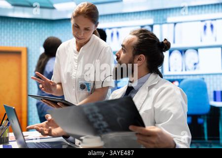 Medical staff collaborates on diagnostic procedures and treatment plans. Radiology specialists work on accurate diagnosis and effective disease prevention, healthcare industry insurance. Stock Photo