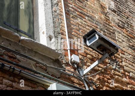 Damaged Old Surveillance Camera on Brick Wall Stock Photo