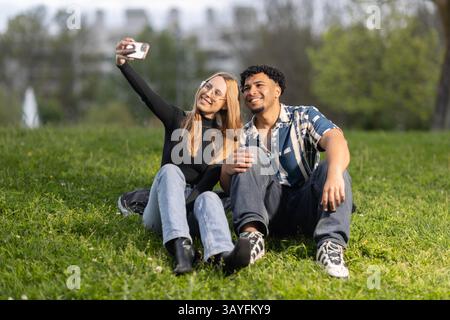 Happy Young Couple Taking Selfie Outdoors in Green Park Stock Photo