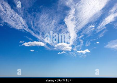 Big Blue Sky with white clouds streak across the sky Stock Photo