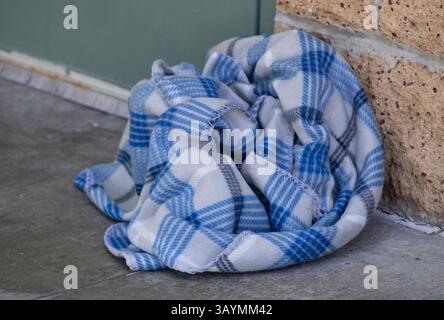 balled up plaid blue and white blanket outside Stock Photo