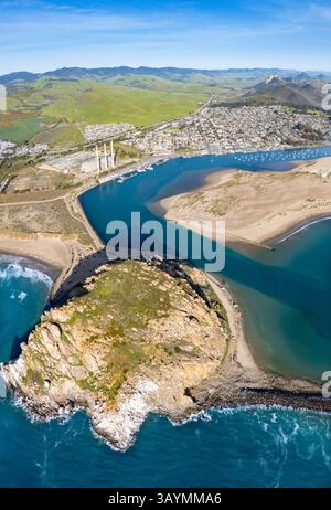 Four images were combined for this aerial panorama view from out over the Pacific Ocean of Morro Rock looking east into the harbor and town of Morro B Stock Photo