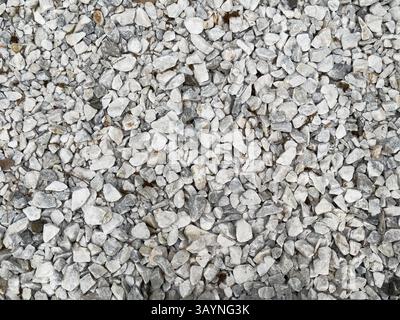 Background of white and grey pebbles and small stones scattered in an even layer on the floor, top view. High quality photo Stock Photo