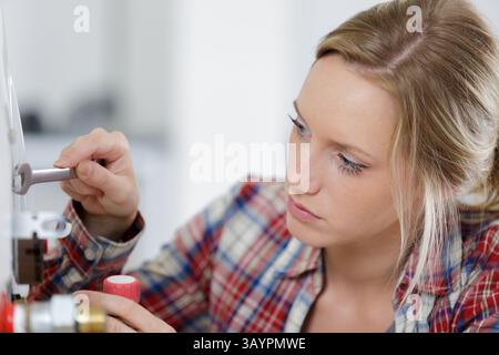 female technician servicing a boiler Stock Photo