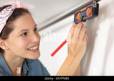 closeup of a blond young woman using spirit level Stock Photo