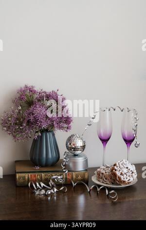 Purple wineglasses on the table with a vase of flowers and finnish traditional funnel cake Stock Photo