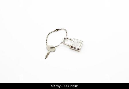 Small padlock and key for bag or suitcase isolated on white background Stock Photo
