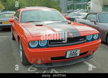 Three-quarters front view of an Orange 2002 BMW Tii (E10) and a Blue