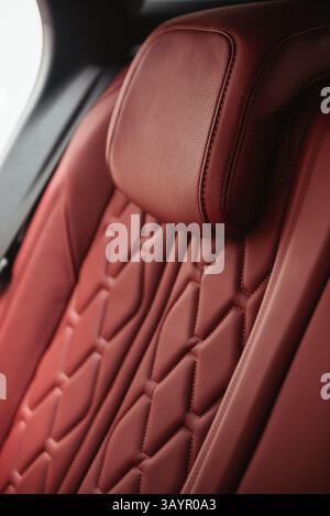 Rear leather seat in a car - close-up view. SUV interior with red leather seats. Stock Photo