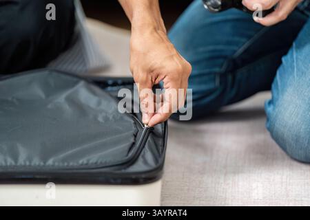 Couple Preparing for Travel. A loving couple packing their suitcase together for an upcoming trip. Stock Photo
