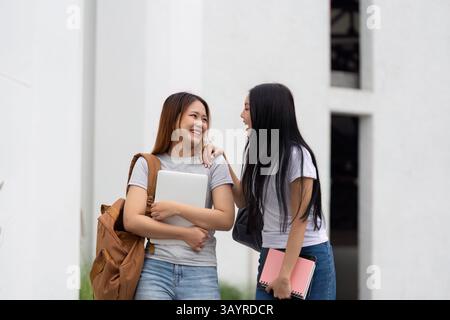 Campus Life and Social Connections. Two students share a joyful moment while discussing their day. Stock Photo