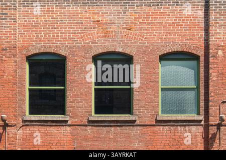Red Brick Elevation and Three Sash Windows Stock Photo