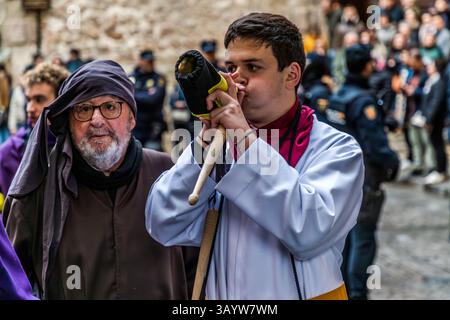 Turbas de Cuenca in purple robes make a deafening noise with their drums (tambores) and trumpets (clarines) at the head of the Camino del Calvario procession, which passes through Cuenca on Good Friday. Calle del Fuero, Cuenca, Castilla-La Mancha, Spain Stock Photo