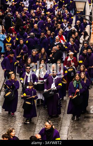 Turbas de Cuenca in purple robes make a deafening noise with their drums (tambores) and trumpets (clarines) at the head of the Camino del Calvario procession, which passes through Cuenca on Good Friday. Plaza Mayor, Cuenca, Castilla-La Mancha, Spain Stock Photo