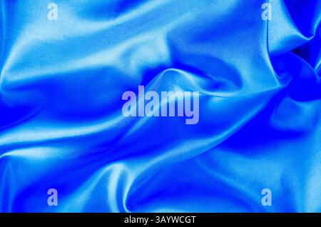 Light blue color silk in soft, smooth waves with a glossy finish. Suitable for design and wallpaper background. Stock Photo