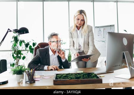 Professional business colleagues collaborating in modern office environment focusing on teamwork and productivity Stock Photo