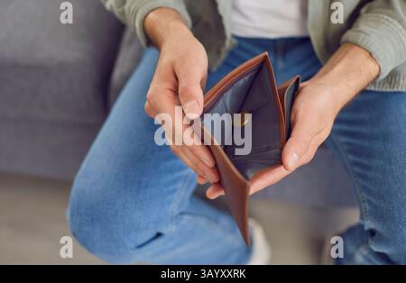 Close Up Shot Of Man Showing Empty Open Wallet Stock Photo