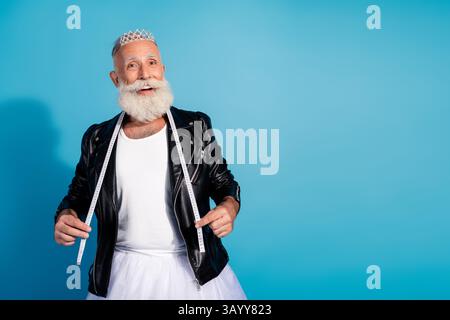 Photo of positive old senior man hold centimeter tape standing in woman clothes black blazer isolated blue color background Stock Photo