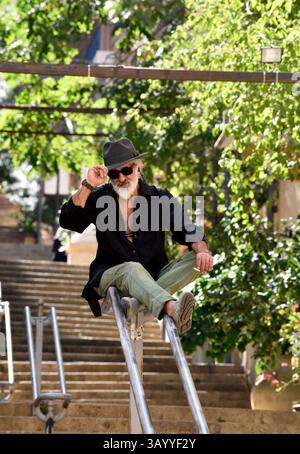 Man sitting on handrail on steps, Gemmayze, Beirut, Lebanon Stock Photo