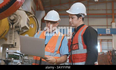 Engineer teaching apprentice to use metal sheet stamping machine Stock Photo