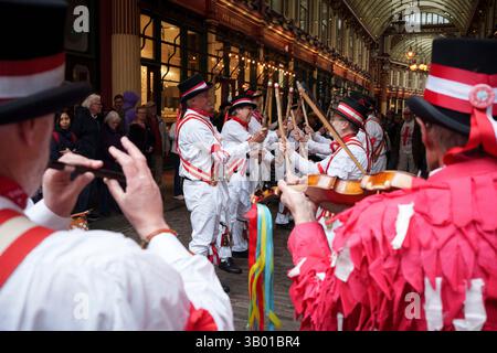 Members of the Elwell St Mary's Morris Men dance jigs in Leadenhall Market on St George's Day, the day that England celebrates its national date, on 23rd April 2025, in the City of London, England. Morris dancing is a form of English folk dance accompanied by accordion and pipes. It is based on rhythmic stepping and the execution of choreographed figures by a group of dancers. Implements such as sticks, swords, and handkerchiefs may also be wielded by the dancers. English records of Morris dancing date back to the 15th century. Stock Photo