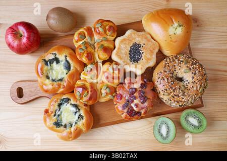 Mouthwatering assorted savory and dessert breads on a wooden breadboard Stock Photo